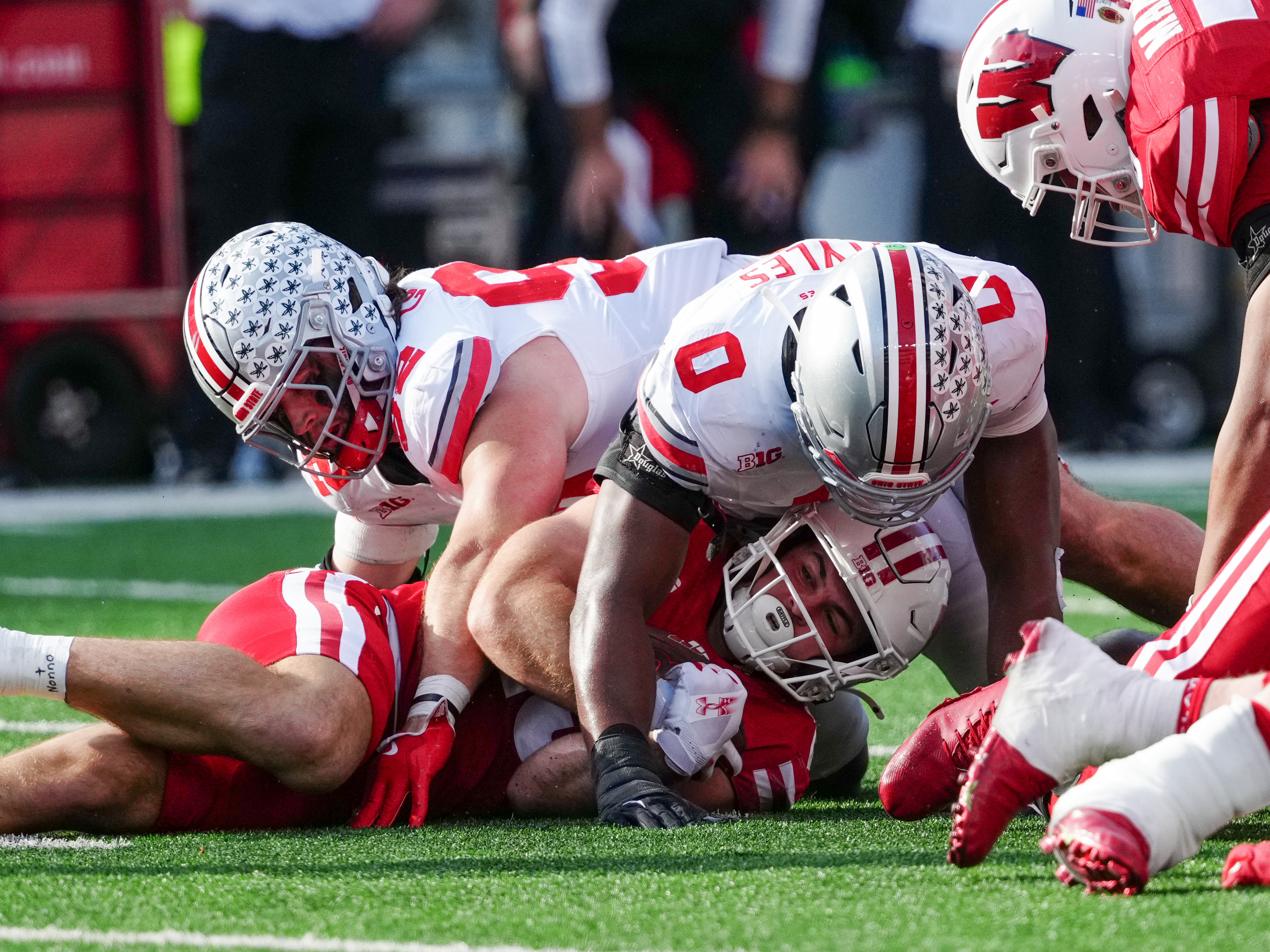 Oct 18, 2025; Madison, Wisconsin, USA; Wisconsin Badgers running back Cade Yacamelli (25) is tackled by Ohio State Buckeyes defensive end Caden Curry (92) and linebacker Sonny Styles (0) in the first half at Camp Randall Stadium on October 18, 2025 in Madison, Wisconsin. Photography by Ross Harried for Second Crop Sports.